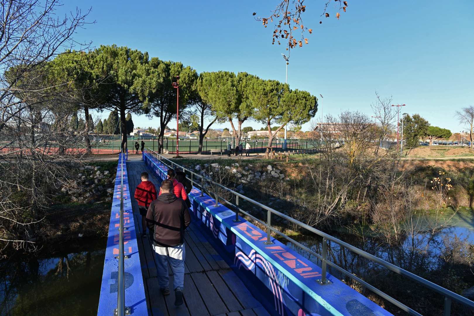 Passerelle sur le Coulazou peinte par l'artiste Noon