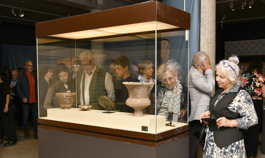des visiteurs devant une vitrine de l'exposition 