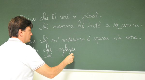 professeur de corse écrivant au tableau d'école